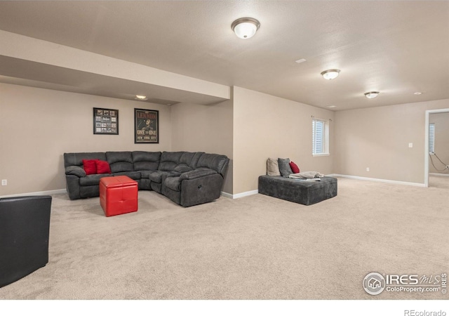 carpeted living area with baseboards