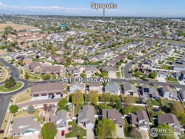 aerial view of property and surrounding area featuring nearby suburban area