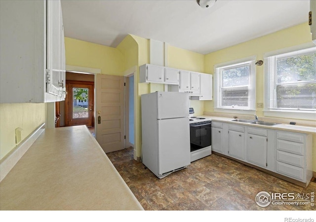 kitchen with white appliances, a sink, healthy amount of natural light, and white cabinetry