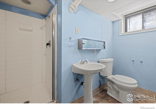 full bathroom featuring a stall shower, toilet, and baseboards
