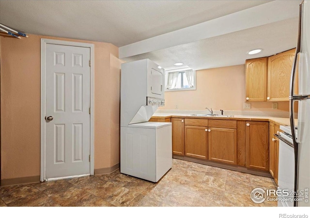 laundry area featuring stacked washer / drying machine and baseboards