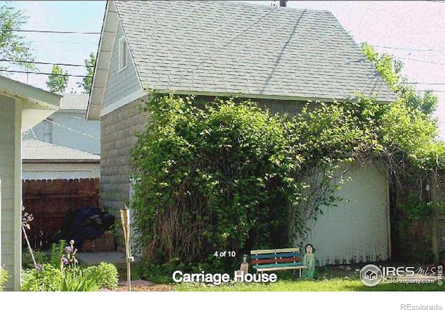 view of side of property with roof with shingles