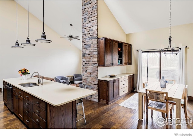 kitchen featuring a sink, dark wood-style flooring, a chandelier, high vaulted ceiling, and a ceiling fan