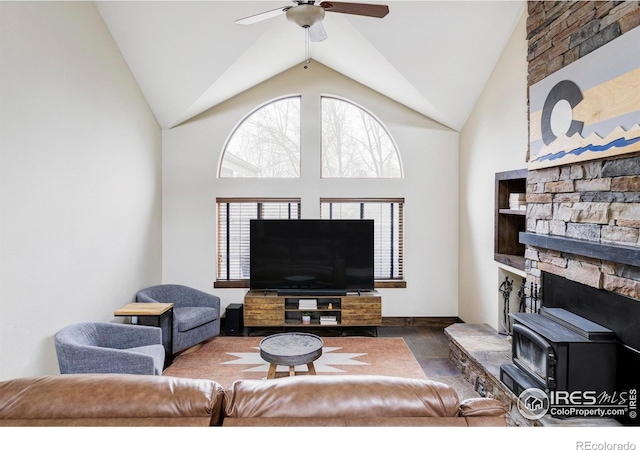 living room featuring a ceiling fan, high vaulted ceiling, and baseboards