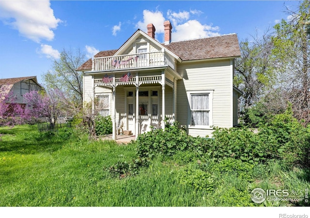 1341 N 95th St, Lafayette, CO 80026 - victorian house featuring a balcony, a chimney, and a front yard