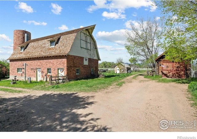 1341 N 95th St, Lafayette, CO 80026 - view of side of home with a gambrel roof, a barn, an outdoor structure, a chimney, and dirt driveway
