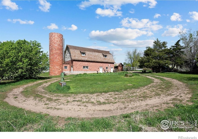 1341 N 95th St, Lafayette, CO 80026 - view of side of property featuring a gambrel roof, a chimney, dirt driveway, and a lawn