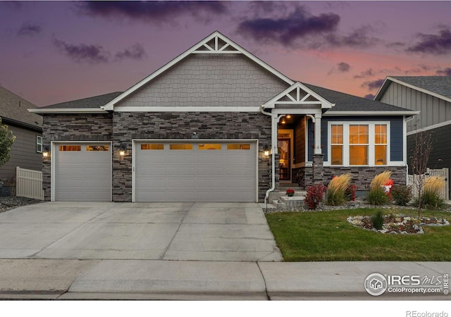 craftsman house with an attached garage, stone siding, driveway, and a lawn
