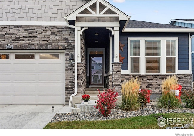 view of exterior entry featuring stone siding and an attached garage