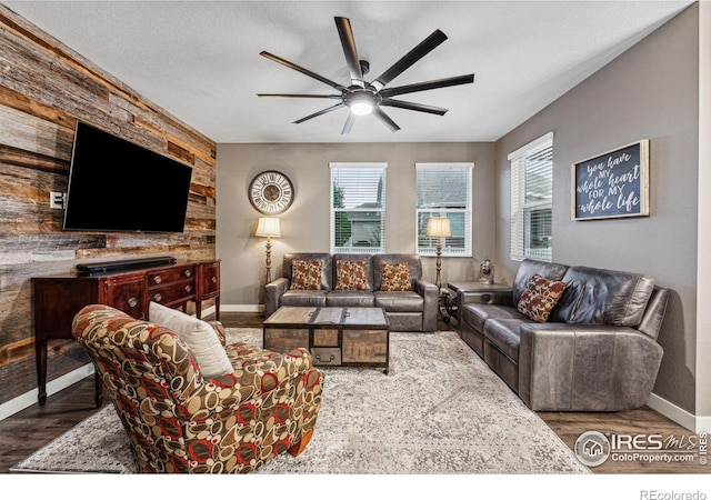 living room featuring a ceiling fan, plenty of natural light, baseboards, and wood finished floors