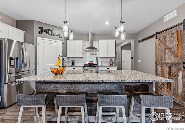 kitchen featuring stainless steel refrigerator with ice dispenser, wall chimney exhaust hood, a sink, dark wood finished floors, and decorative backsplash