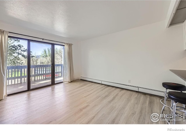 3363 Oneal Pkwy Unit 36, Boulder, CO 80301 - unfurnished living room with light wood-style floors, a baseboard heating unit, a textured ceiling, and baseboards