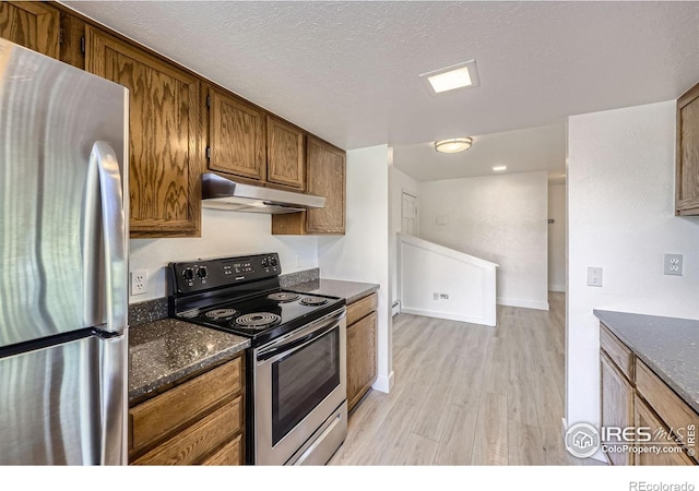 3363 Oneal Pkwy Unit 36, Boulder, CO 80301 - kitchen with appliances with stainless steel finishes, under cabinet range hood, light wood-type flooring, brown cabinets, and a textured ceiling