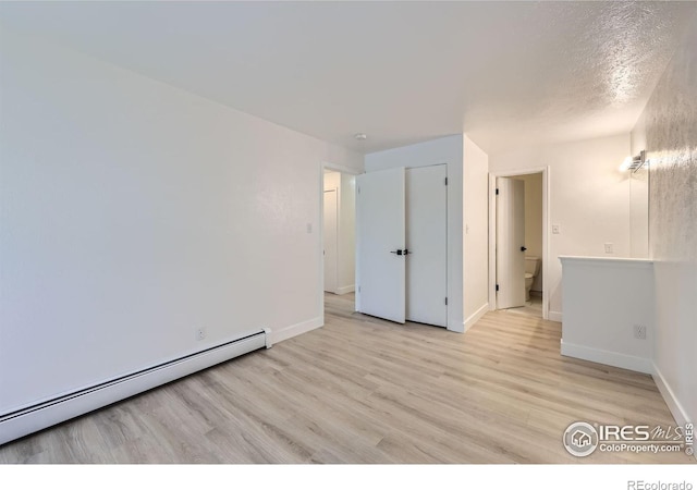 3363 Oneal Pkwy Unit 36, Boulder, CO 80301 - spare room featuring a baseboard radiator, light wood-type flooring, and baseboards