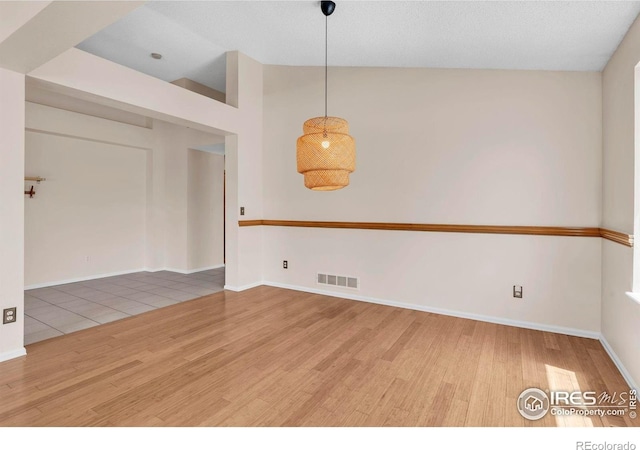 1606 Iris St, Broomfield, CO 80020 - spare room featuring wood finished floors, vaulted ceiling, and baseboards