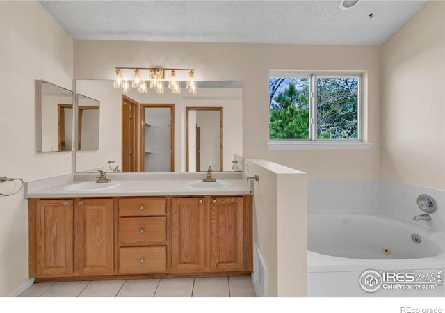 1606 Iris St, Broomfield, CO 80020 - full bathroom featuring a tub with jets, double vanity, tile patterned floors, and a textured ceiling