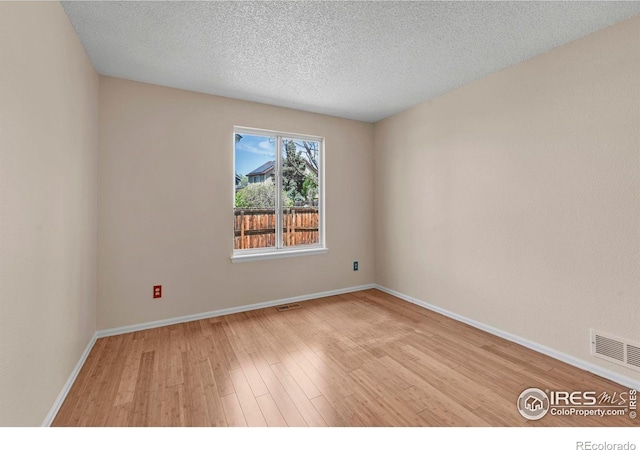 1606 Iris St, Broomfield, CO 80020 - unfurnished room with light wood-style floors, baseboards, and a textured ceiling