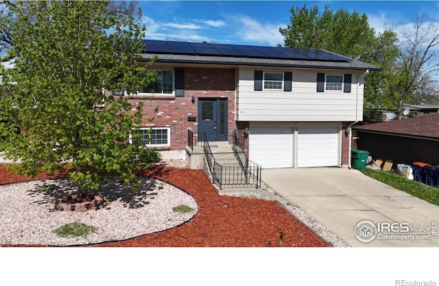 8351 Ralph Ln, Denver, CO 80221 - raised ranch with brick siding, solar panels, and a garage