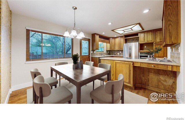 8351 Ralph Ln, Denver, CO 80221 - dining space with healthy amount of natural light, light wood finished floors, baseboards, recessed lighting, and a chandelier