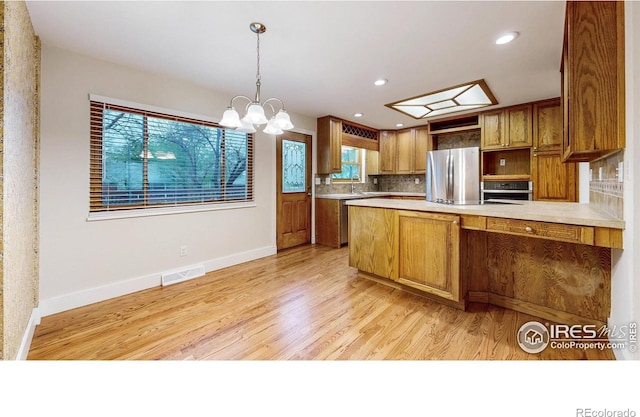 8351 Ralph Ln, Denver, CO 80221 - kitchen featuring stainless steel appliances, healthy amount of natural light, a peninsula, tasteful backsplash, and recessed lighting