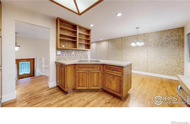 8351 Ralph Ln, Denver, CO 80221 - kitchen featuring light wood-style flooring, open shelves, a chandelier, brown cabinetry, and light countertops