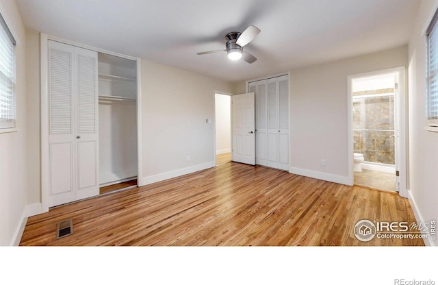 8351 Ralph Ln, Denver, CO 80221 - unfurnished bedroom with multiple closets, wood finished floors, baseboards, and multiple windows