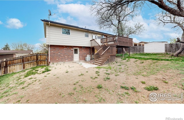 8351 Ralph Ln, Denver, CO 80221 - back of property with stairs, a wooden deck, a fenced backyard, and brick siding