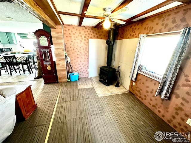 45908 County Road 39, Otis, CO 80743 - unfurnished living room featuring a wood stove, wallpapered walls, and ceiling fan