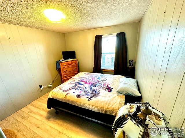 45908 County Road 39, Otis, CO 80743 - bedroom with wood finished floors, wooden walls, and a textured ceiling