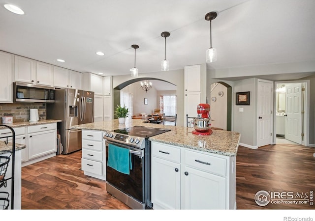 13106 Elizabeth St, Thornton, CO 80241 - kitchen featuring appliances with stainless steel finishes, arched walkways, white cabinetry, light stone countertops, and recessed lighting