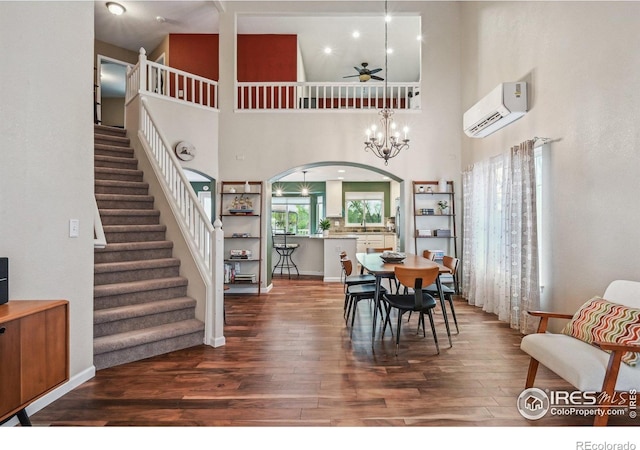 13106 Elizabeth St, Thornton, CO 80241 - dining space with a wall mounted AC, wood finished floors, ceiling fan, stairs, and a towering ceiling