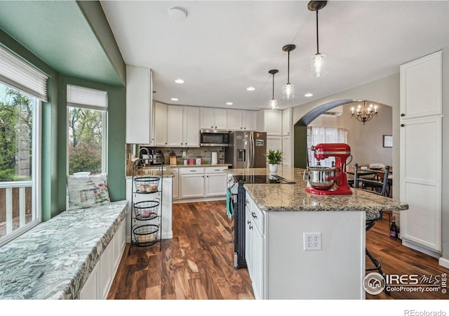 13106 Elizabeth St, Thornton, CO 80241 - kitchen with stainless steel appliances, arched walkways, white cabinets, dark wood-type flooring, and recessed lighting