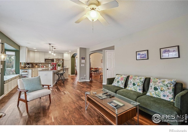 13106 Elizabeth St, Thornton, CO 80241 - living room featuring arched walkways, ceiling fan, and dark wood-style flooring