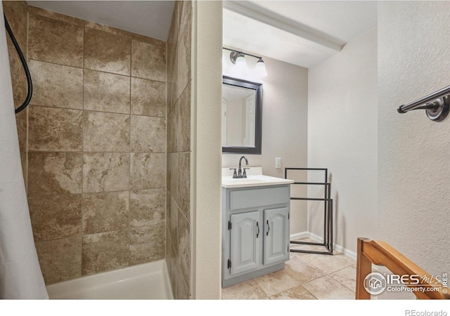 13106 Elizabeth St, Thornton, CO 80241 - bathroom with vanity, tiled shower, tile patterned floors, and a textured wall