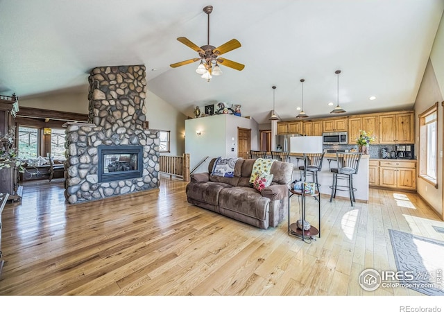 117 Mount Sherman Ct, Livermore, CO 80536 - living area featuring vaulted ceiling, ceiling fan, light wood-type flooring, a fireplace, and recessed lighting