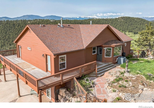 117 Mount Sherman Ct, Livermore, CO 80536 - rear view of property with a wooded view, a deck with mountain view, cooling unit, and a patio
