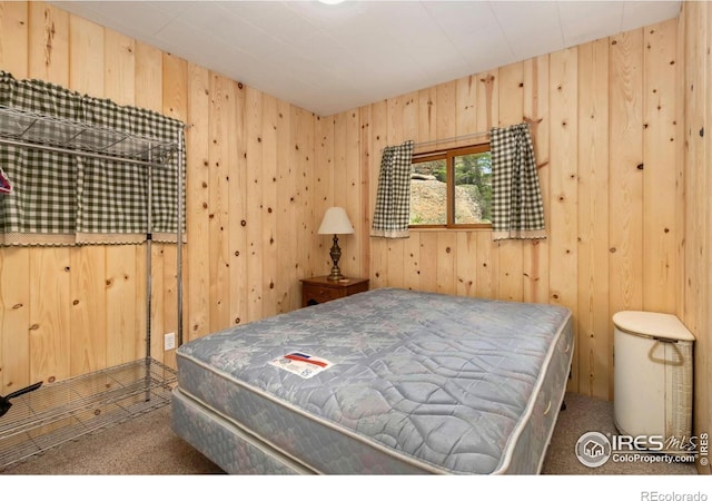 bedroom with carpet and wooden walls