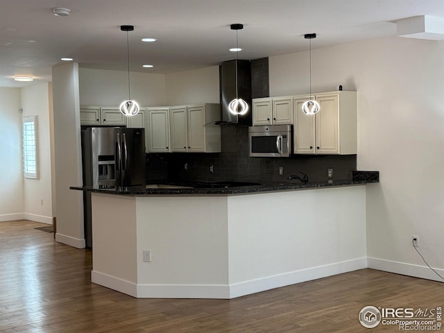 kitchen with stainless steel microwave, baseboards, backsplash, dark stone counters, and wall chimney exhaust hood