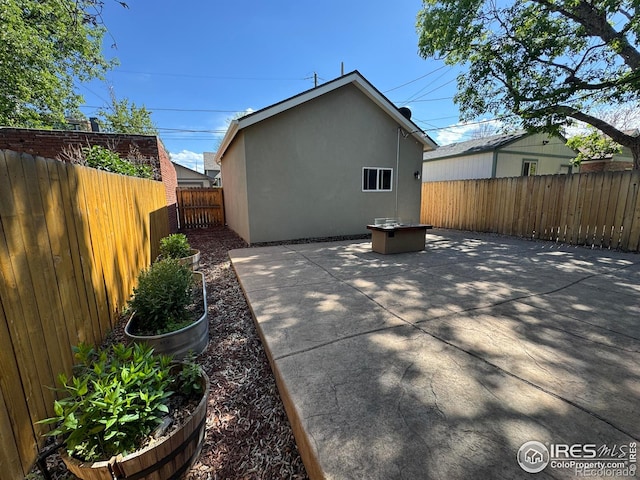 back of property featuring stucco siding, a patio area, and a fenced backyard