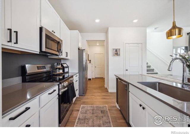700 Lillibrook Pl, Erie, CO 80026 - kitchen with stainless steel appliances, a sink, white cabinets, and recessed lighting