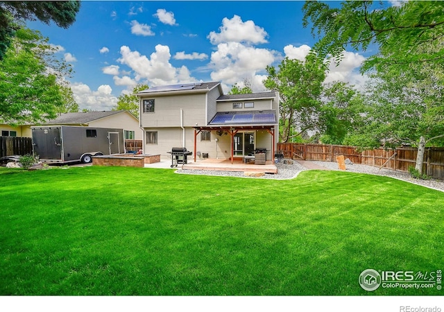 back of property with a patio and roof mounted solar panels