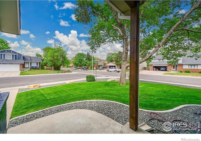 view of green lawn with a residential view