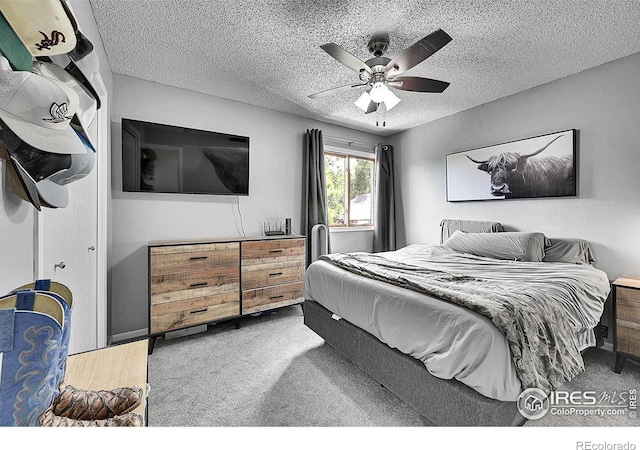 carpeted bedroom featuring a textured ceiling and a ceiling fan