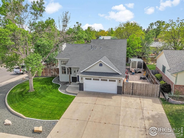 view of front facade with a shingled roof, driveway, and a garage