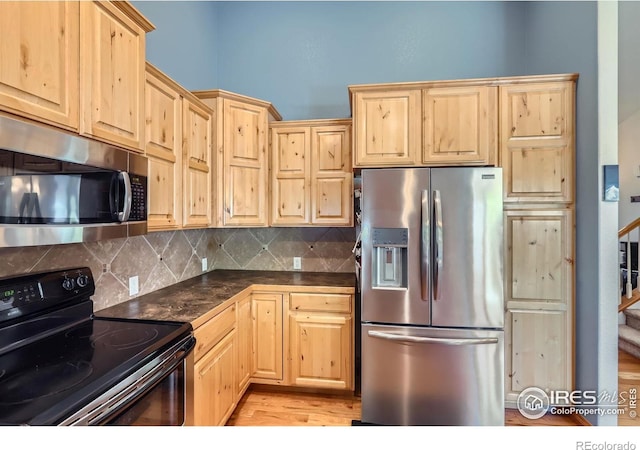 6601 Viburnum St, Wellington, CO 80549 - kitchen featuring stainless steel appliances, light brown cabinets, dark countertops, and backsplash