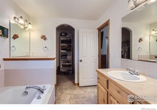6601 Viburnum St, Wellington, CO 80549 - bathroom featuring a spacious closet, a bath, vanity, and backsplash