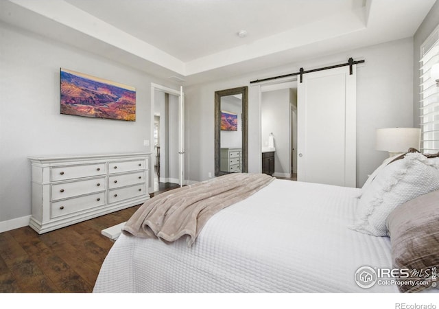 4843 Mariana Hills Cir, Loveland, CO 80537 - bedroom featuring a barn door, wood finished floors, baseboards, and a raised ceiling