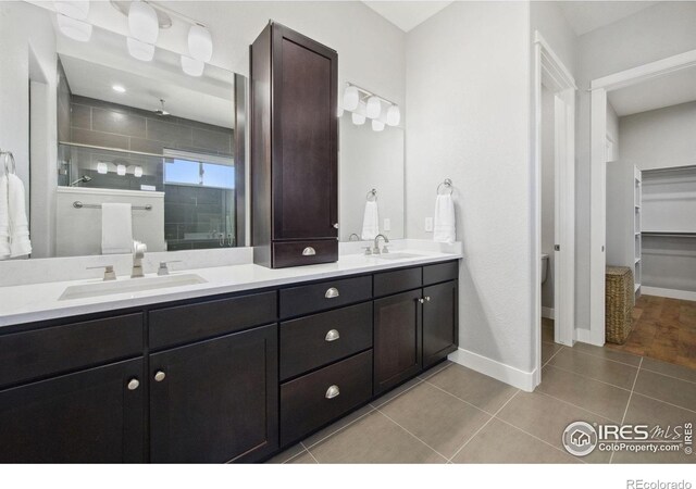 4843 Mariana Hills Cir, Loveland, CO 80537 - bathroom with a tile shower, double vanity, tile patterned floors, and baseboards