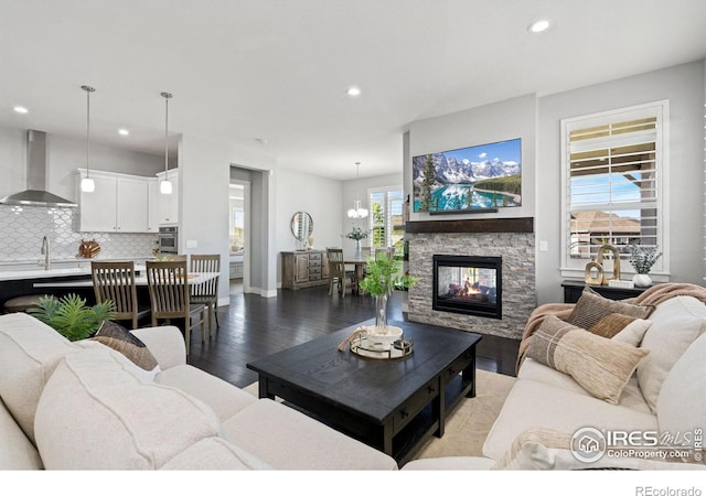 4843 Mariana Hills Cir, Loveland, CO 80537 - living area featuring wood finished floors, recessed lighting, a fireplace, baseboards, and a chandelier