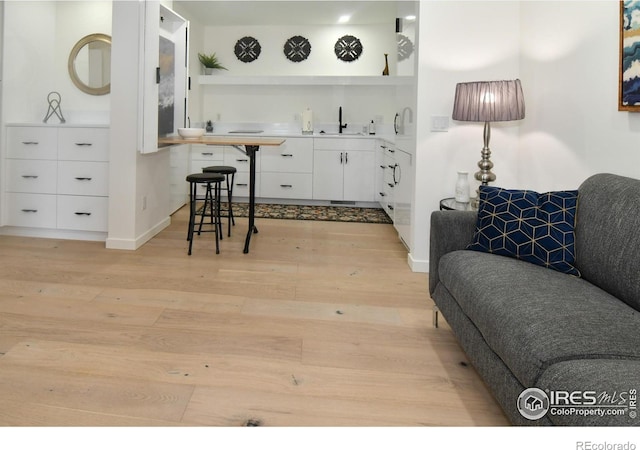 living area with light wood-style flooring and baseboards